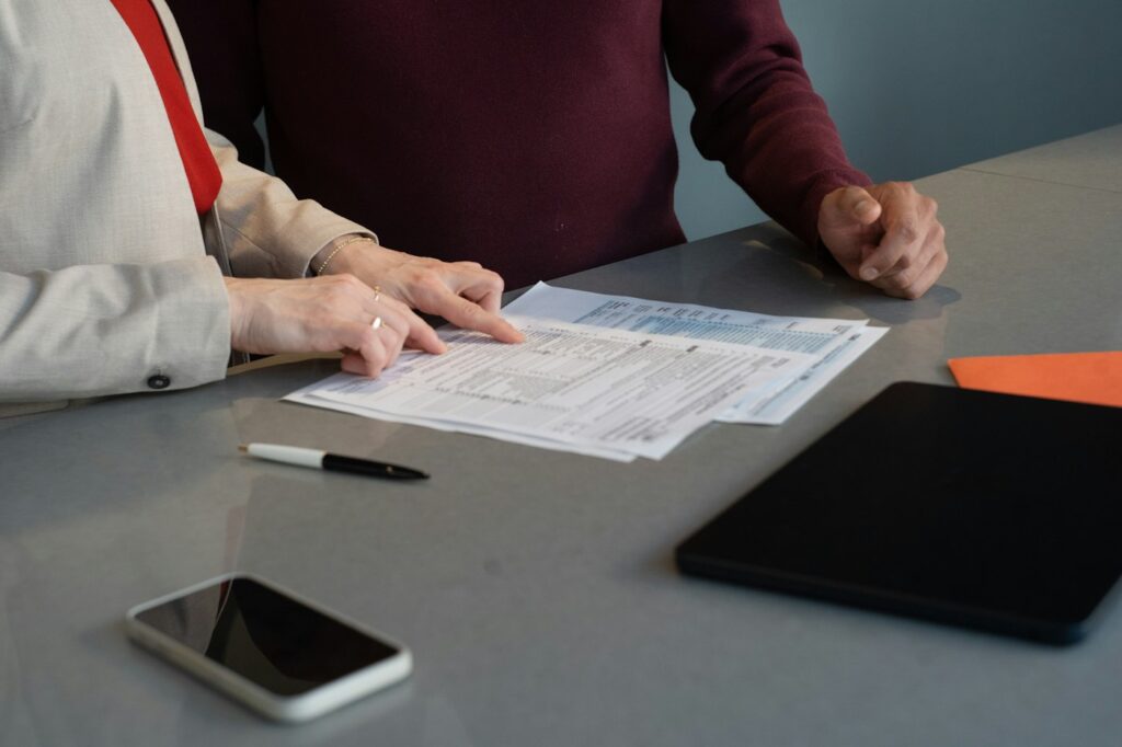 Two professionals reviewing financial paperwork at a conference table