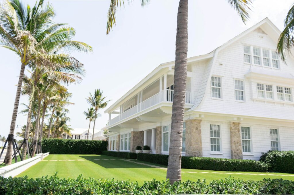 White residential home surrounded by palm trees